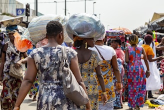 A colorful street market scene in Lagos, Nigeria, bustling with people and vibrant fabrics.