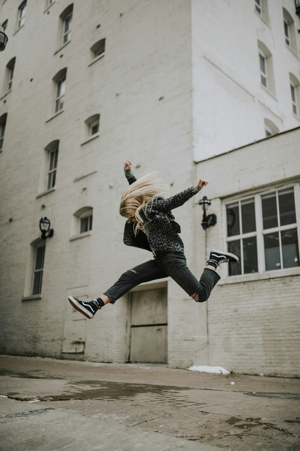 woman jumper near white concrete building