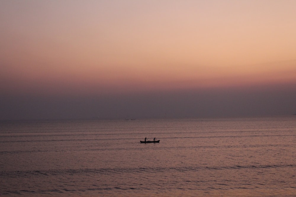 silhouette of boat under gray sky