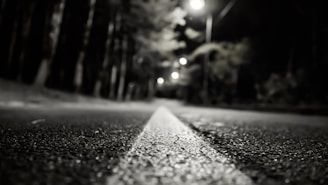 Evening view of a completed asphalt road glistening under streetlights.