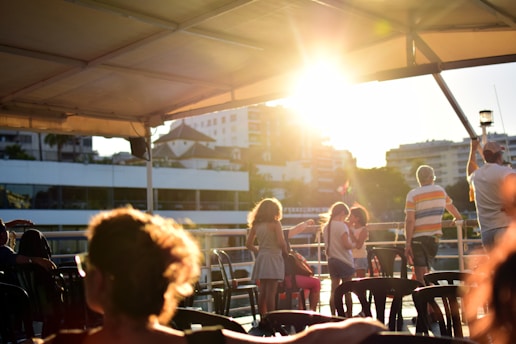 people standing near plastic stools on rooftop