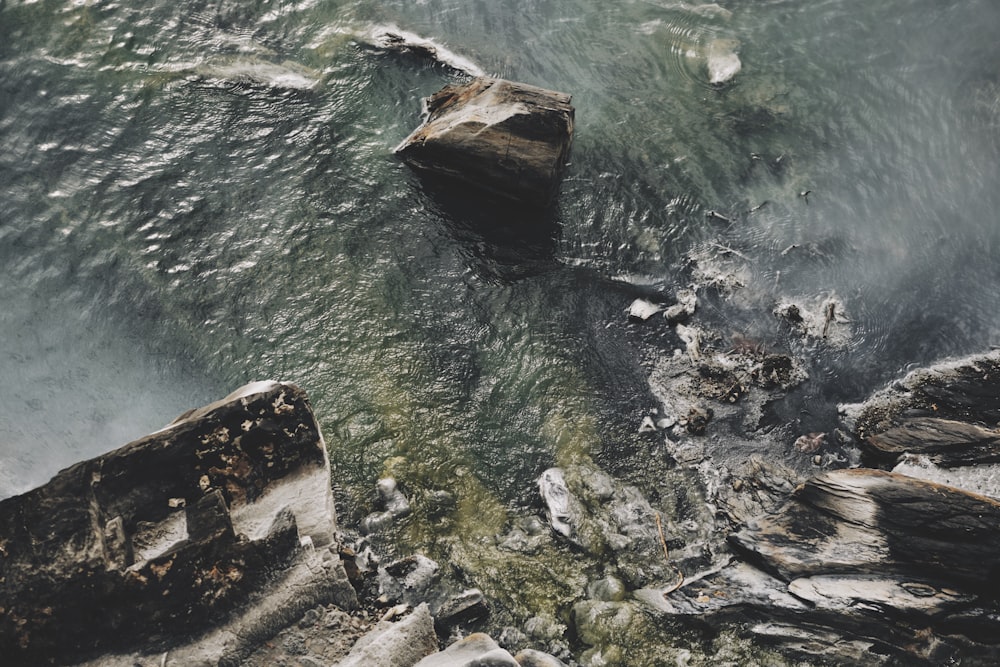 brown rock formation beside body of water