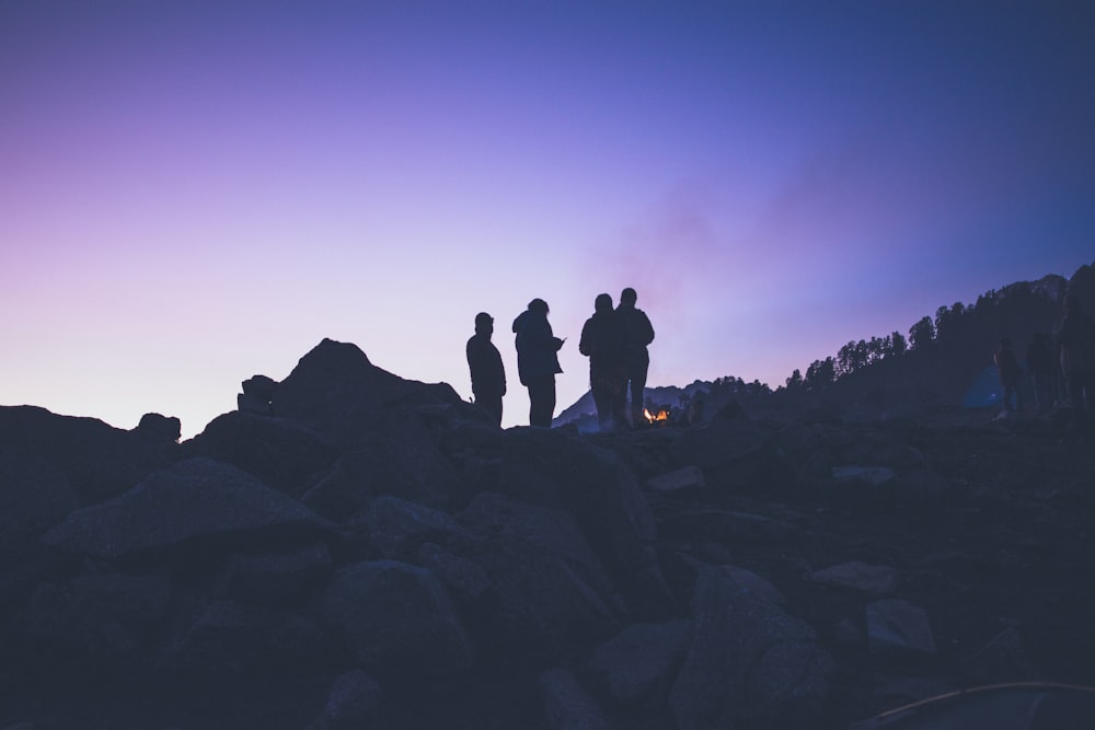 silhouette of people on mountain during golden hour