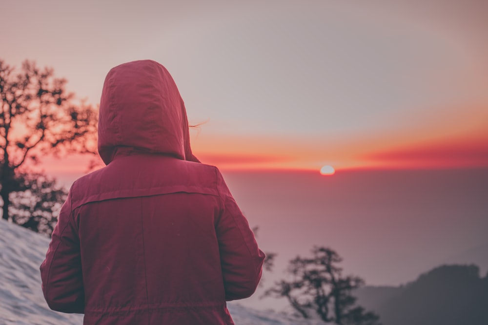 person standing front of mountain during golden hour