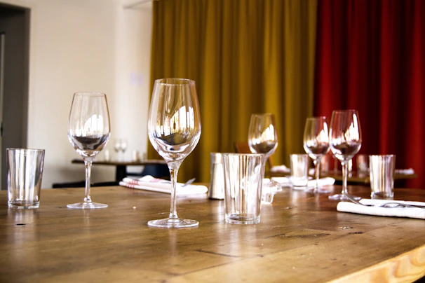 Close-up of a wooden table set with local wine and glasses.