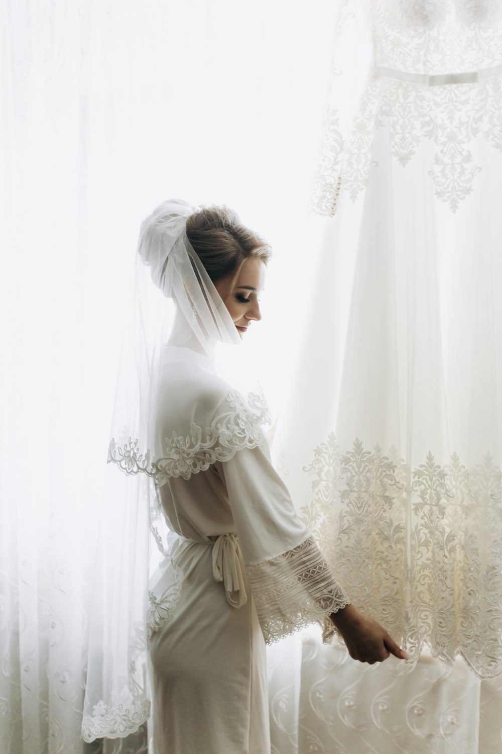 woman standing beside curtain