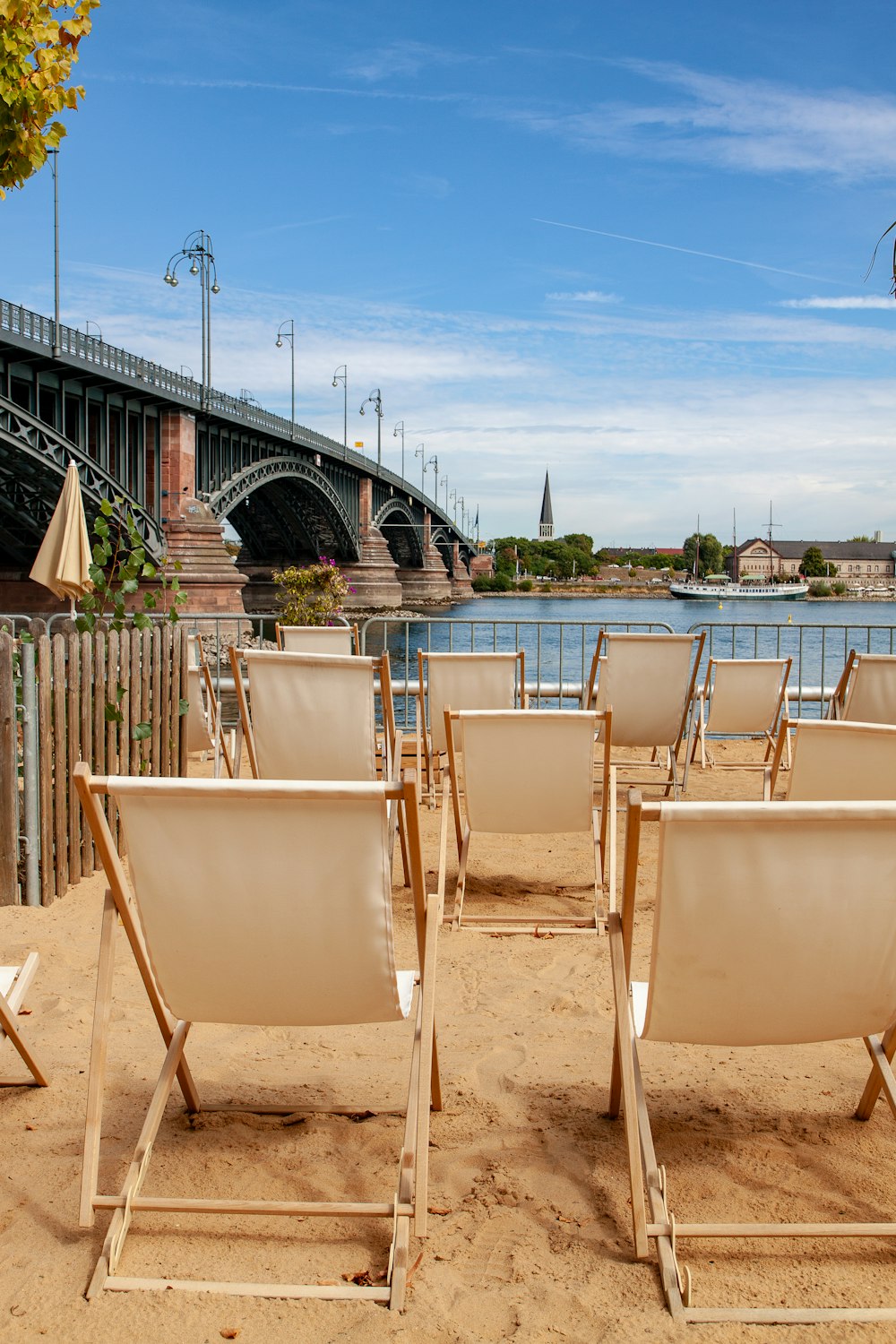 Chaises en bois beige au bord de l’eau pendant la journée