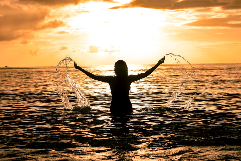 woman swimming on the ocean during sunset view