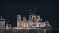 Historic cathedral illuminated at night with deep blue sky background.