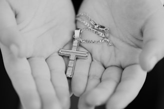 silver-colored necklace with cross pendant