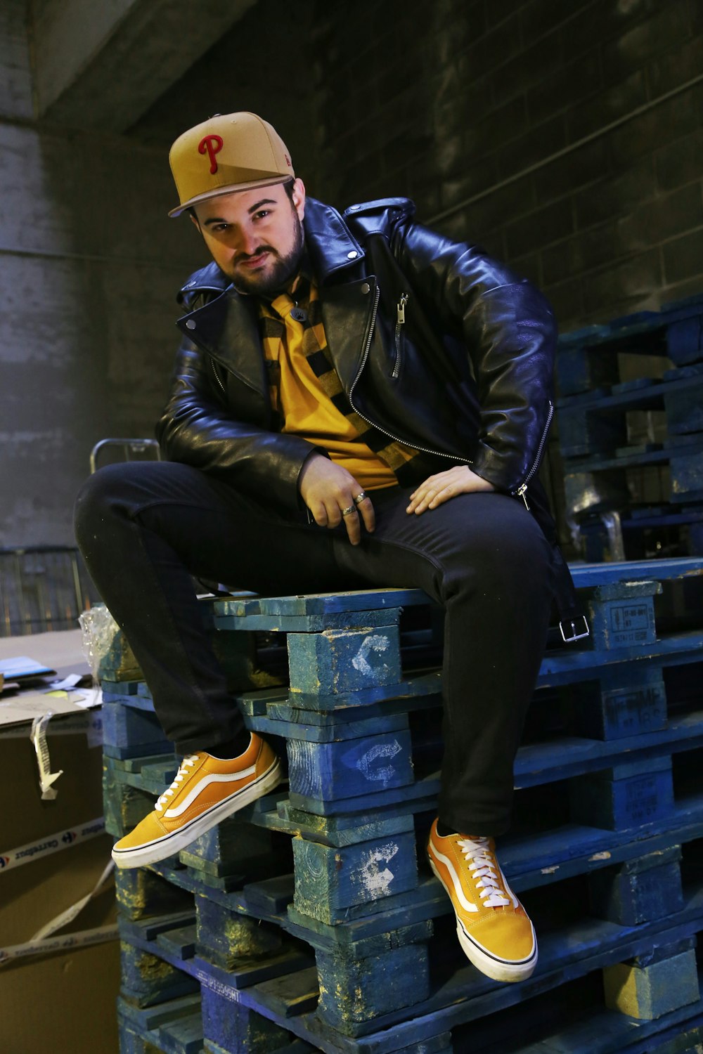 man sitting on blue wooden crates