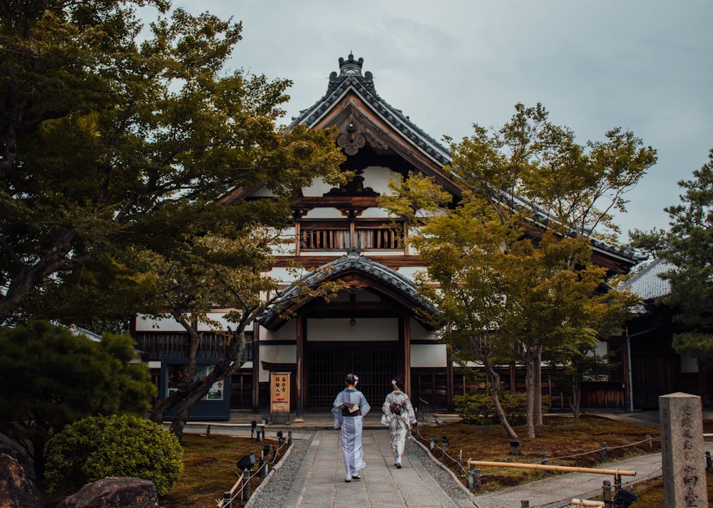 two Gesha walking on concrete walkway beside trees