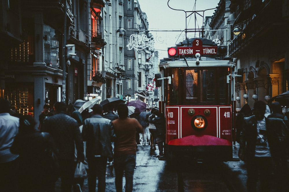 people walking beside building and train