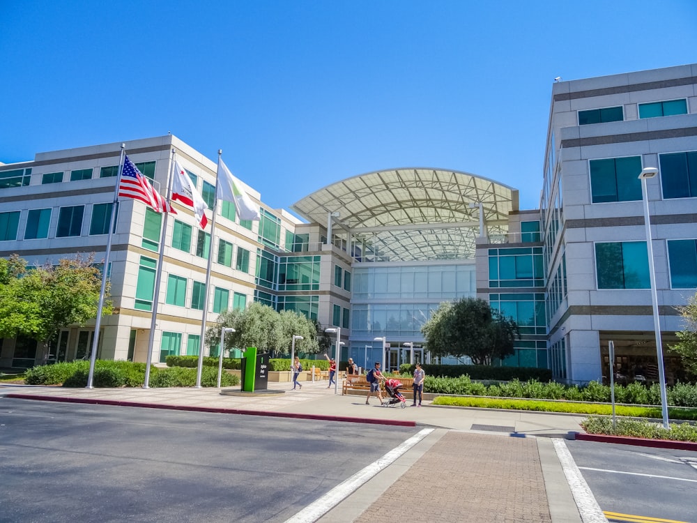 people walking on pathways near building under clear blue sky at daytime