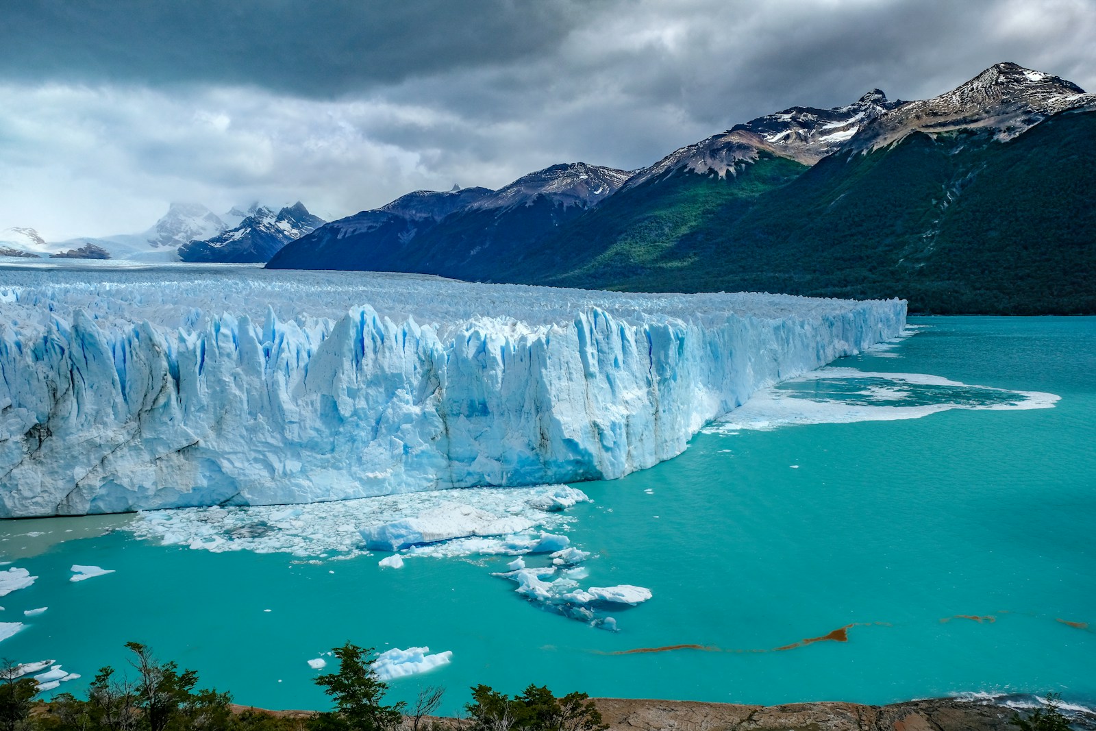 The blue-white front of the Perito Moreno glacier stretching across a turquoise lake, ringed by Patagonian mountains