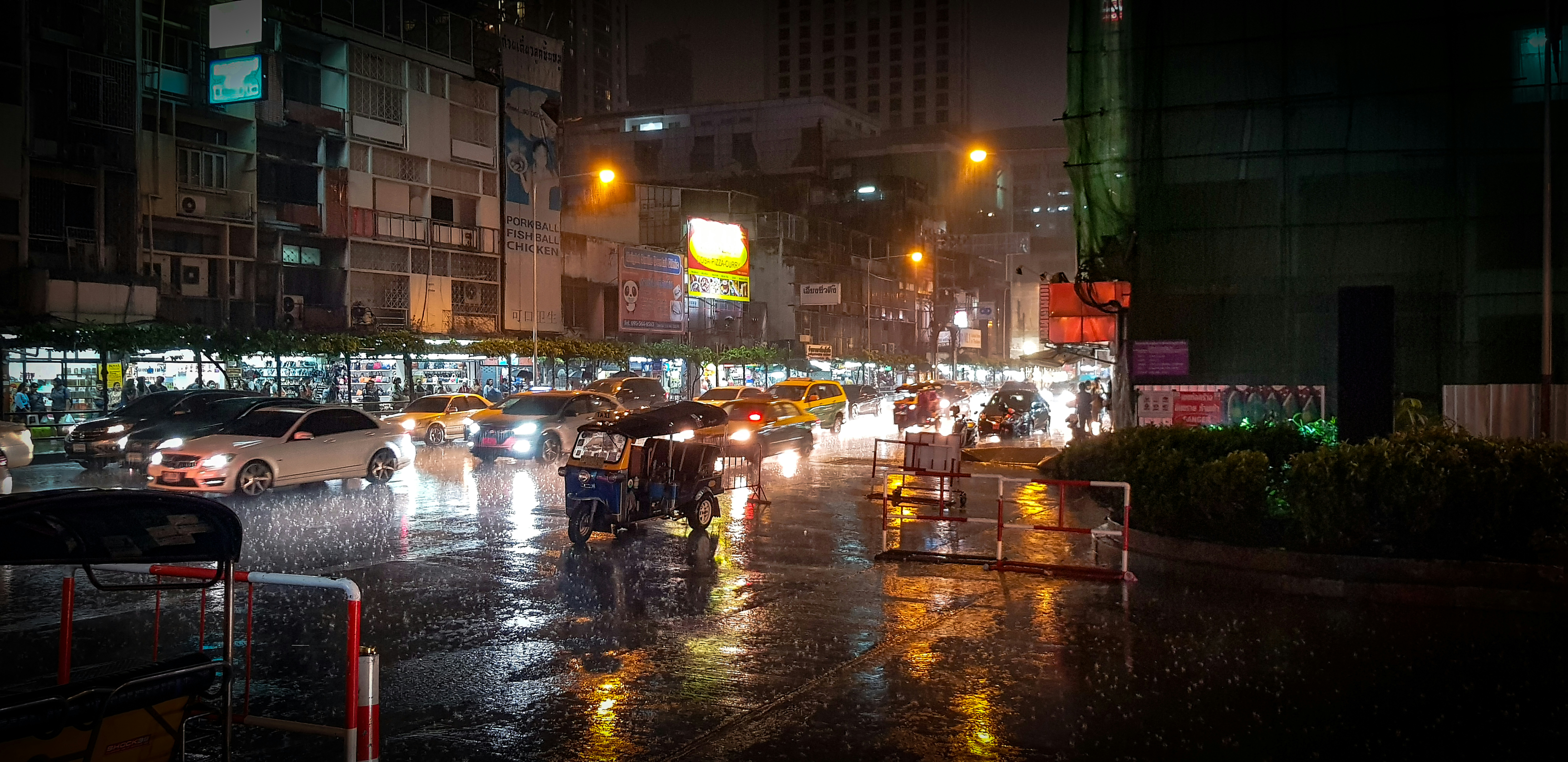 A close-up shot of heavy rain lashing down on a street in a northeastern Indian city, with visible waterlogging.