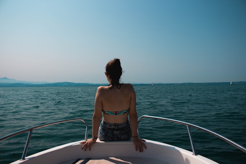 Chic woman seated on yacht edge