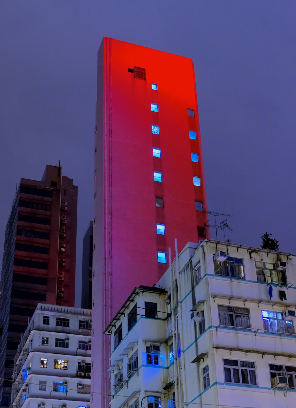 Fotografia de foco raso de arranha-céus vermelhos durante a noite