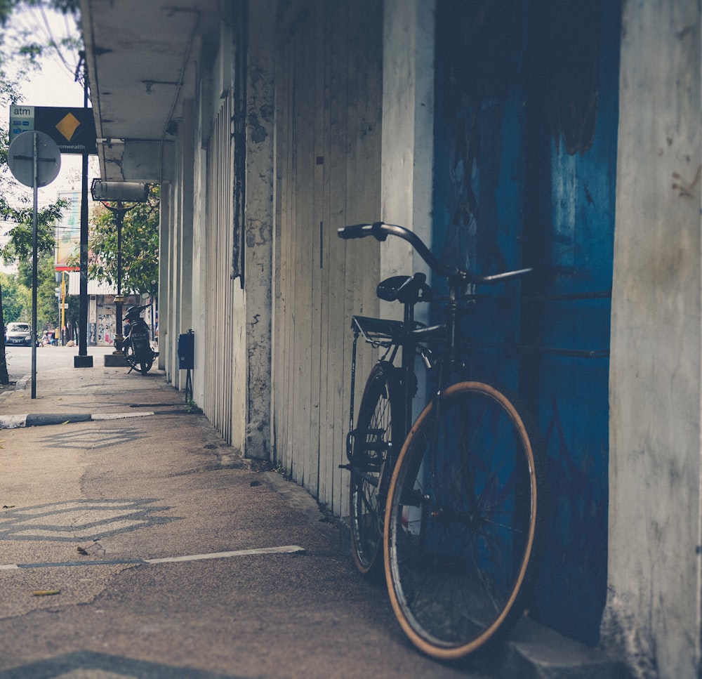 Aparcamiento de bicicletas de cercanías negro cerca de la puerta azul