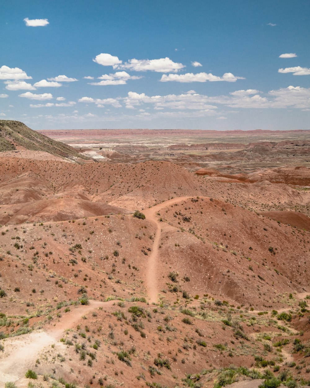 dirt and grass covered hills during day