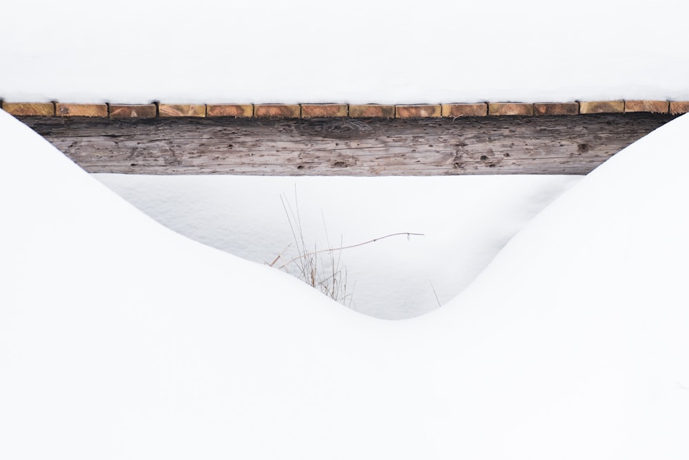 a wooden bridge over a snow covered field