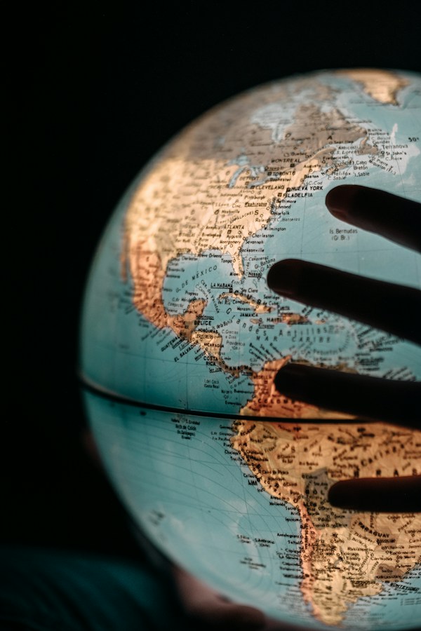 Hand tracing international markets on a globe