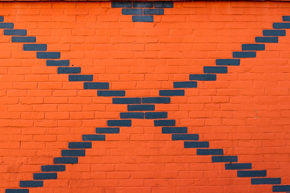 an orange brick wall with a blue arrow painted on it