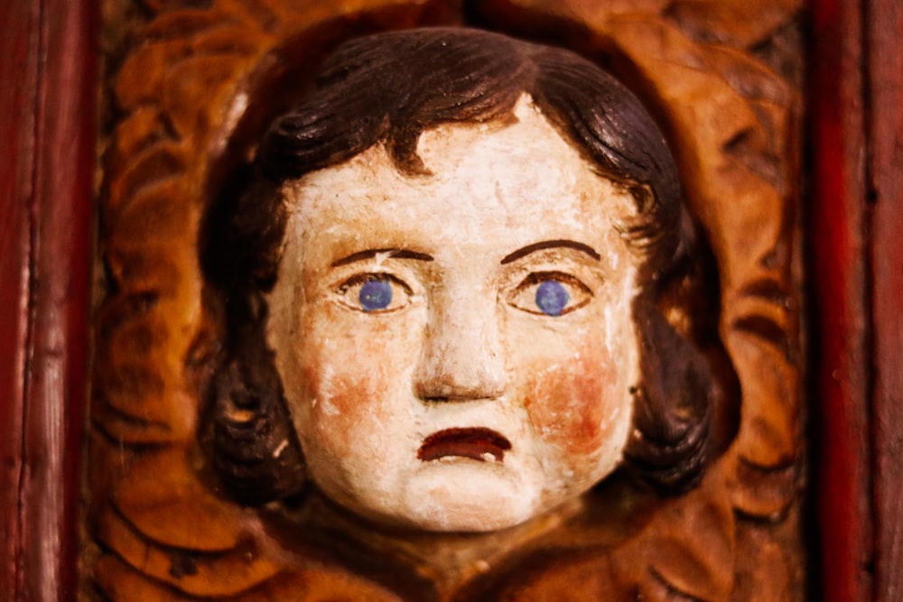 cara de niña tallada en madera