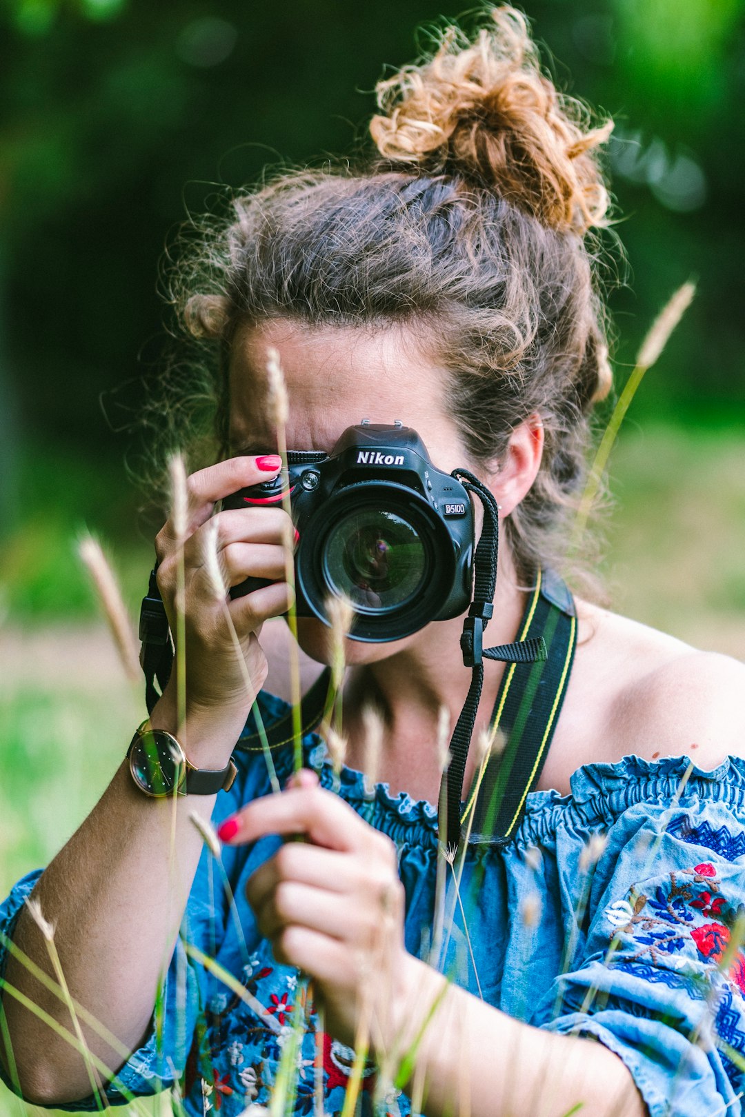 woman wearing blue dress holding camera during daytime