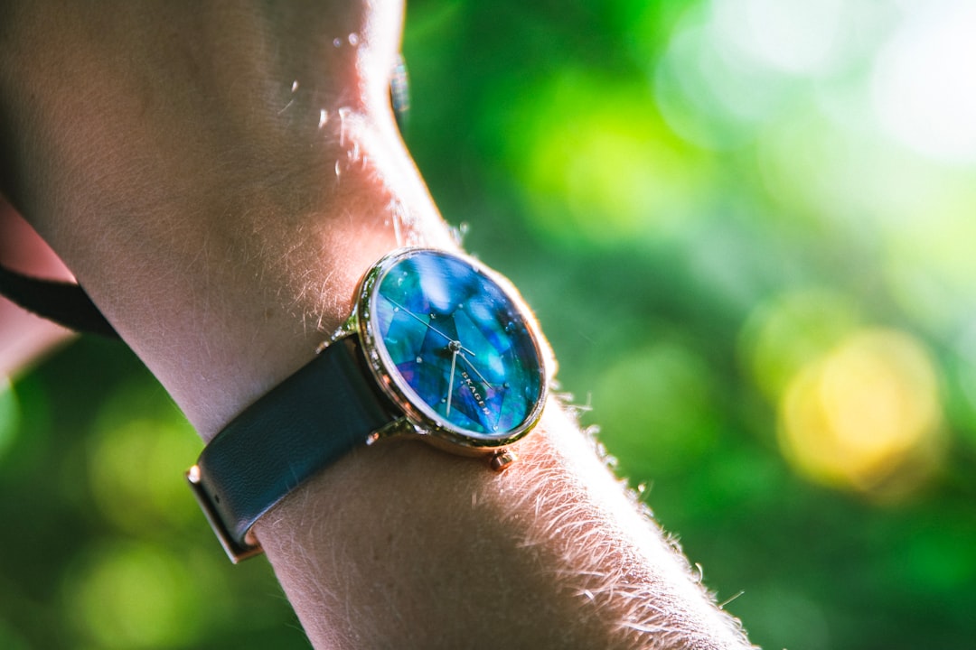 round blue analog watch with black leather strap