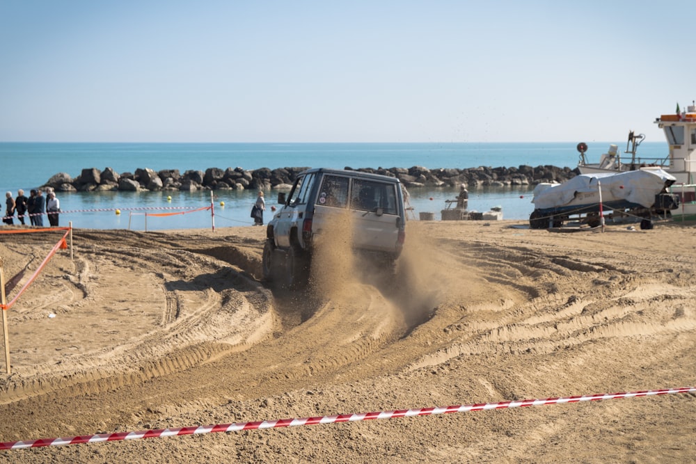 Véhicule blanc sur le sable pendant la journée