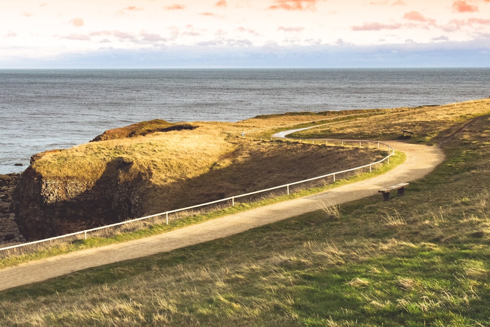 dirt road near the ocean during day