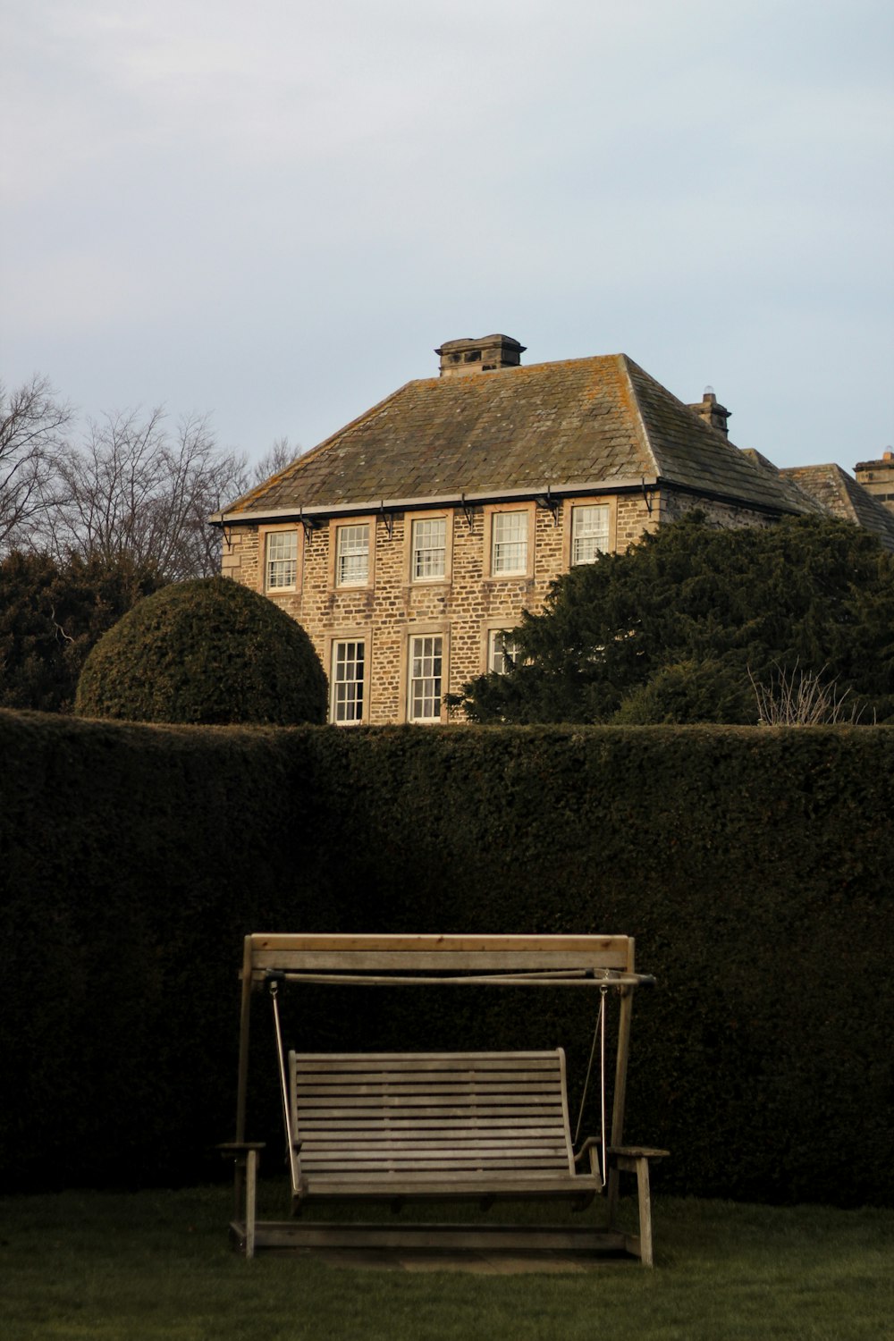 brown house near green hedge