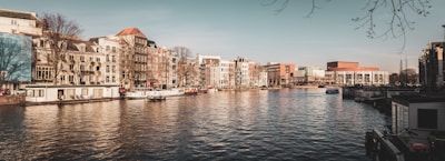A serene view of Amsterdam's canals with business buildings in the background.