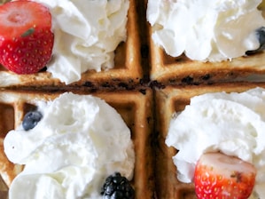 Golden waffles drizzled with syrup and sprinkled with fresh berries.