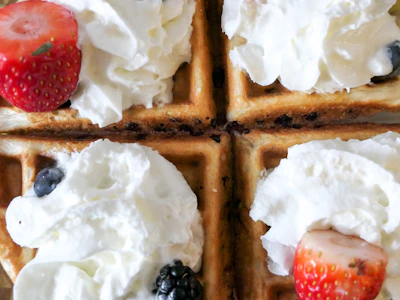 A creamy protein waffle topped with fresh berries and a drizzle of honey.
