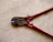 A pair of red bolt cutters rests on a concrete surface. The metal jaws and pivot mechanism are visible, showcasing the tool's sturdy construction.