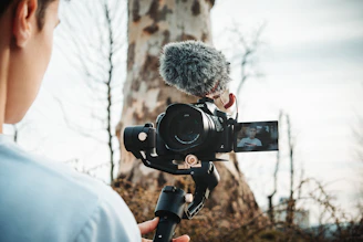 person talking video of himself near tree during daytime