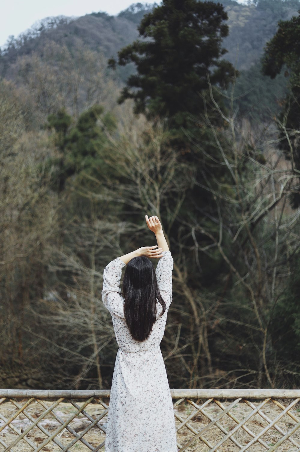 woman raised both hands near fence