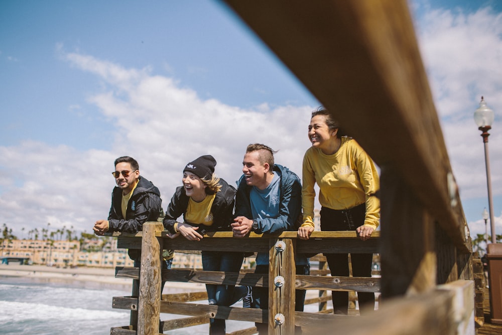 four person standing on the ocean dock photography