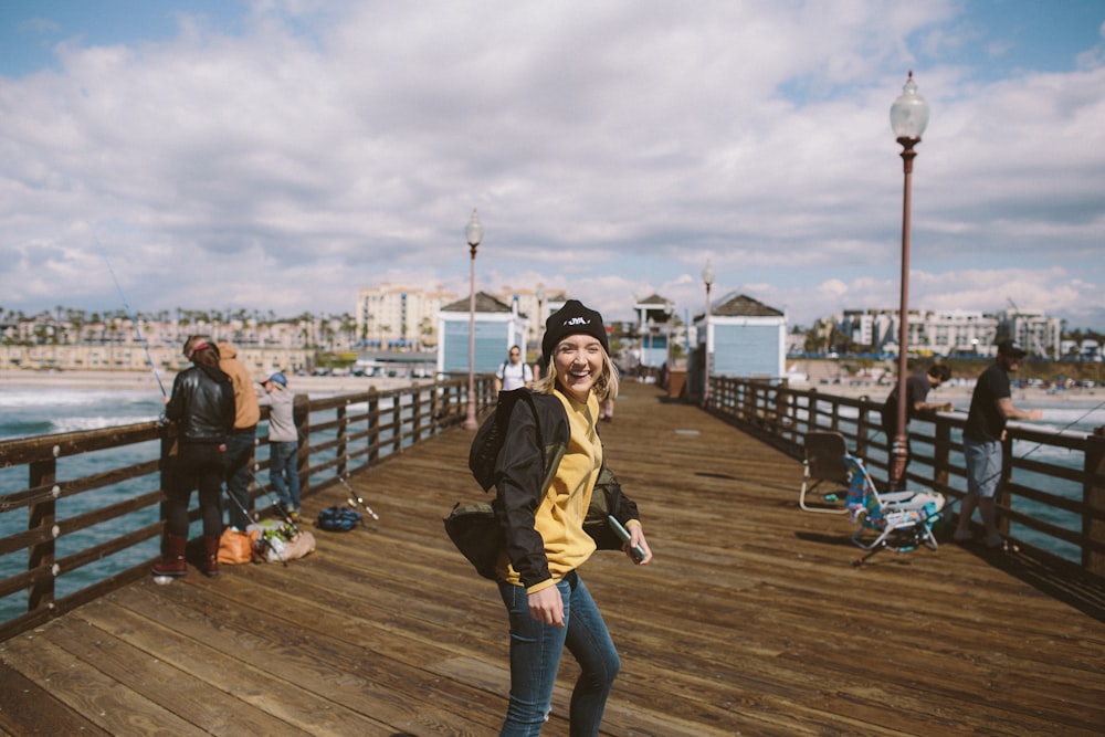 woman standing on brown wooden dock