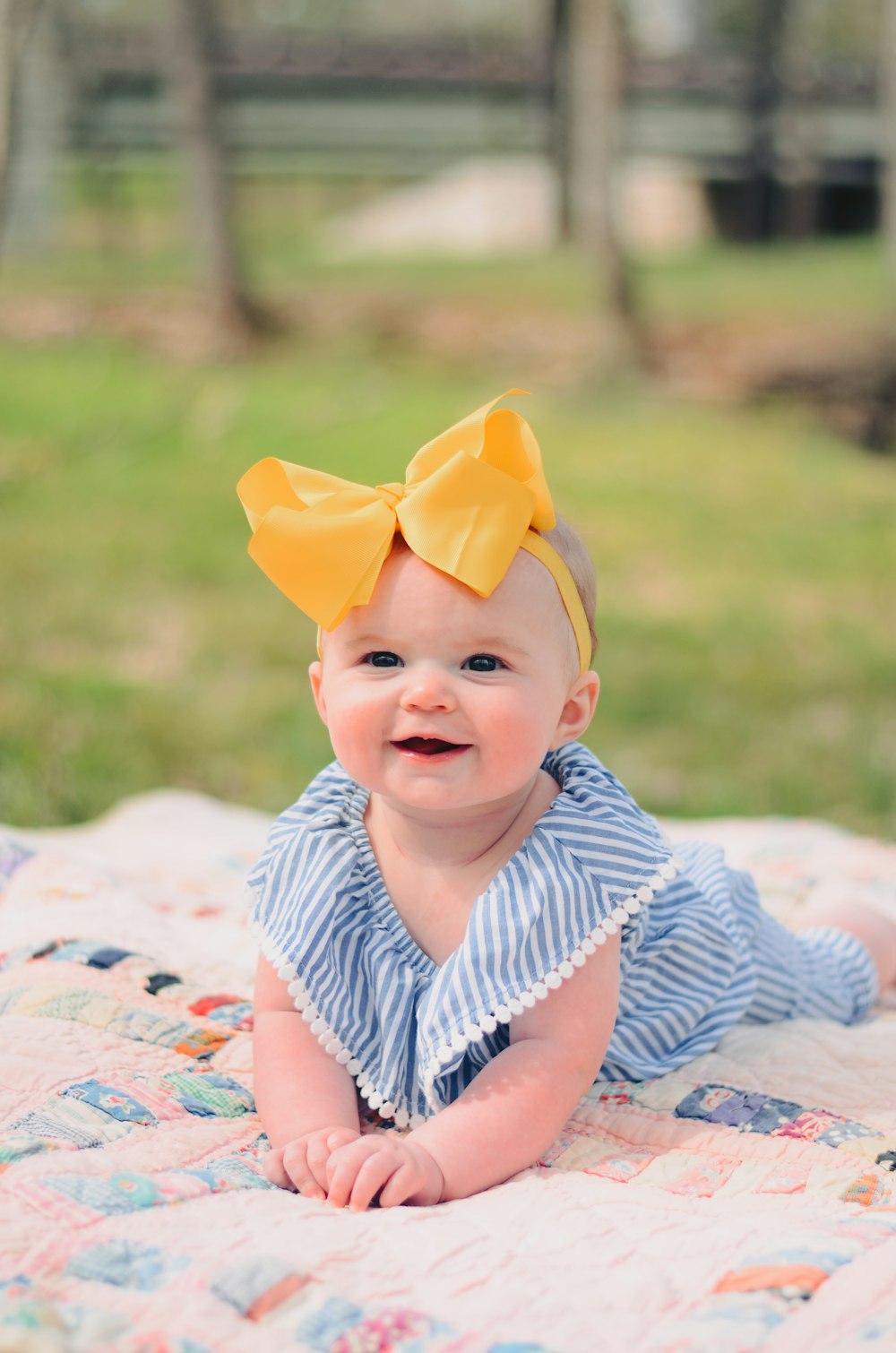 smiling baby lying forward on pink textile