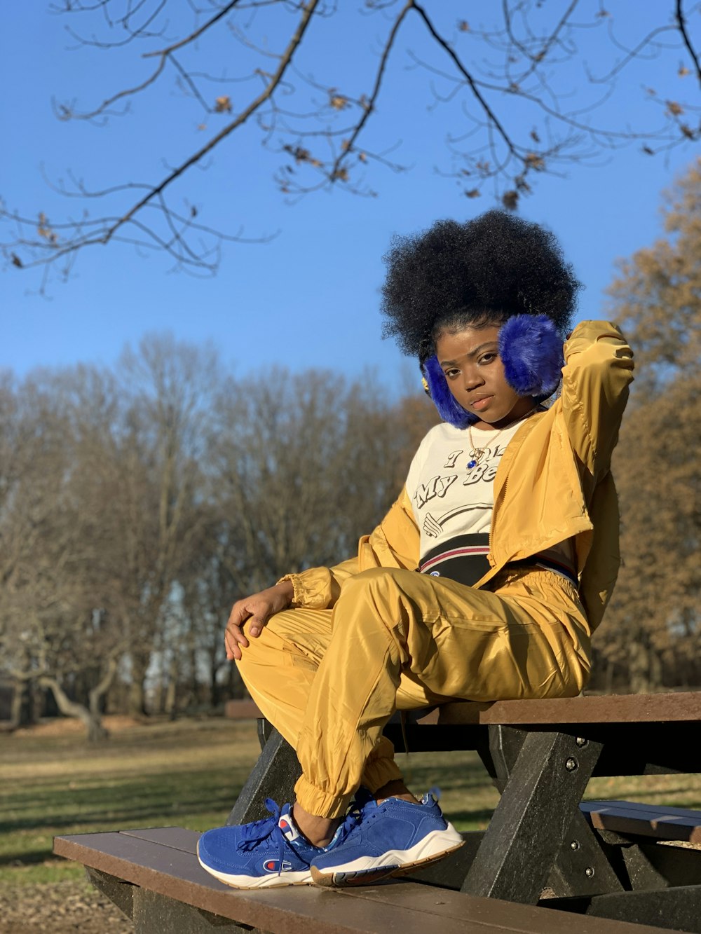 woman sitting on picnic table under tree during daytime