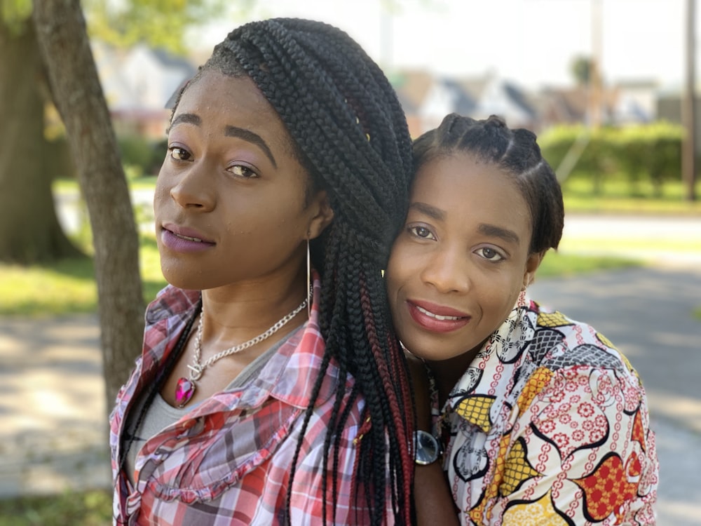 two women standing near tree