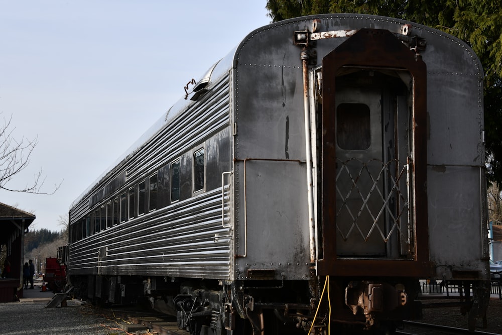 train on station near tree at daytime