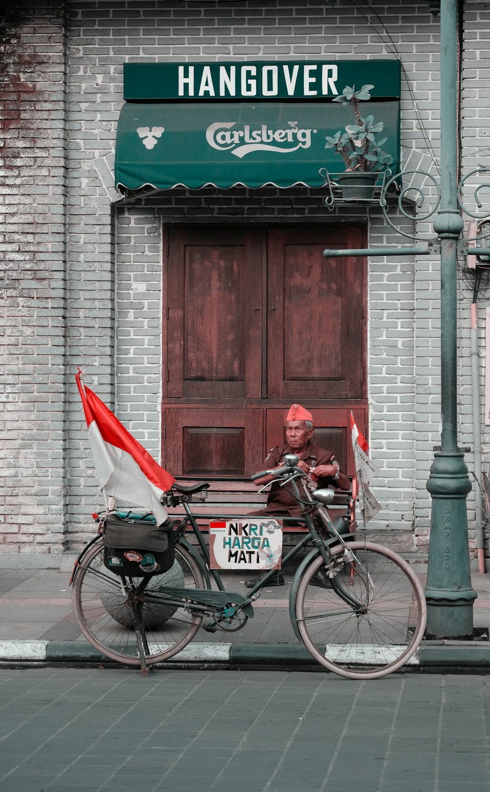 man sitting on doorstep beside parked bicycle