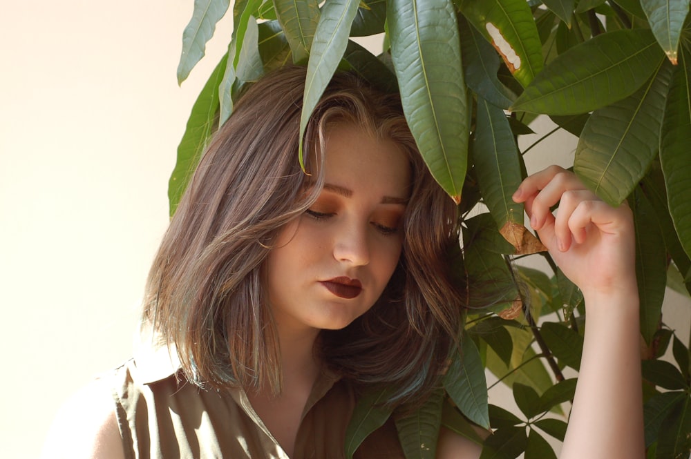 woman beside green-leafed plant