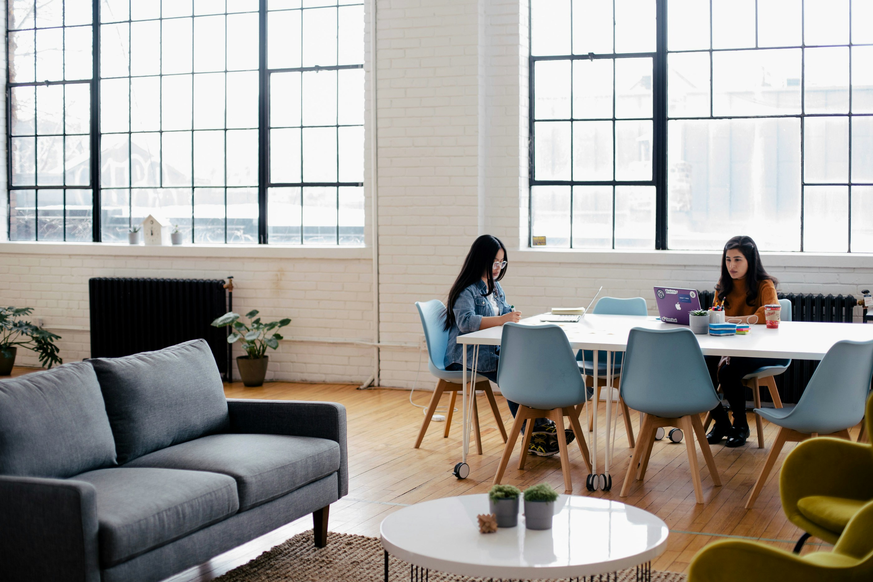 two women sitting in front of white table lounge chair