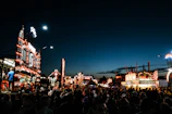 Evening scene of a food festival with vibrant stalls and happy visitors.
