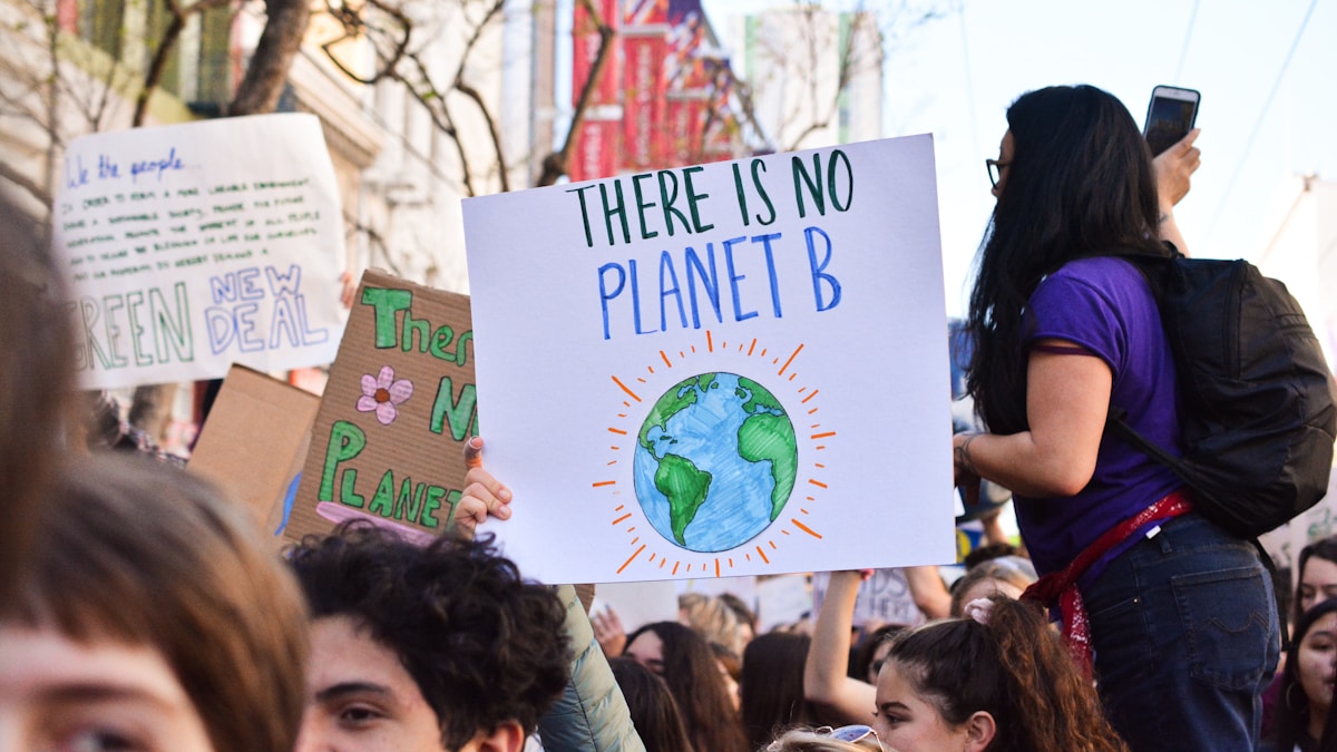 person holding there is no planet b poster